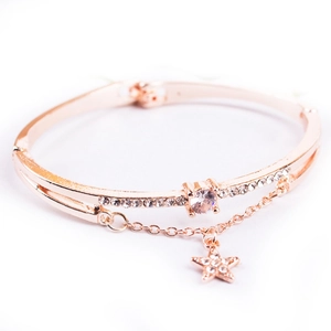 Detail of rose gold double-layer bracelet with sparkling crystals and star pendant