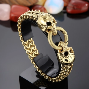 Punk style golden stainless steel bracelet featuring double skulls and textured ring clasp
