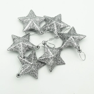 Set of six silver glitter star Christmas tree ornaments with hanging strings on white background