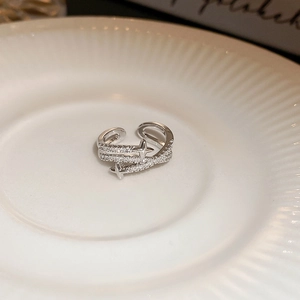 Close-up of adjustable silver cross star ring with micro-pave cubic zirconia stones