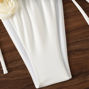 Detail of white bikini with 3D floral accent and breathable mesh panels