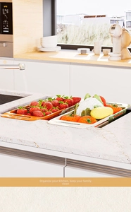 Detail of retractable dual-layer drain basket with produce over a kitchen sink