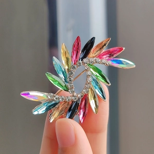 Fashionable crystal brooch featuring multi-color marquise-cut stones in a symmetric metal design