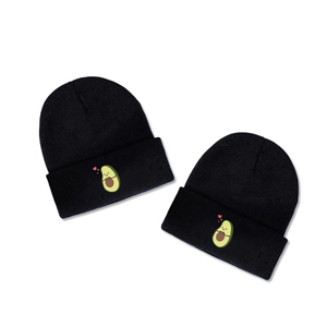 Two black knitted beanies featuring embroidered avocado with heart on a white background