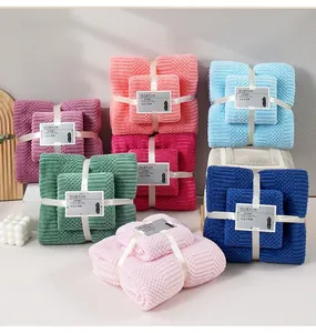 Close-up of soft coral fleece towel set with waffle texture and elegant ribbon bow