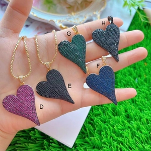 Macro detail of five gold-plated micro-pave heart pendants in various vibrant colors