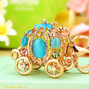 Macro shot of gold pumpkin carriage keychain with blue opal stones and sparkling rhinestones