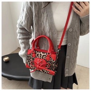 Detail of leopard print mini bag with red heart bow and silver metal hardware