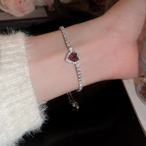 Close-up of heart-shaped red gemstone bracelet with sparkling pavé adjustable chain