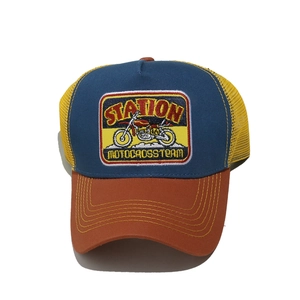 Detail of vintage motocross team embroidery patch on mesh trucker hat with contrast colors