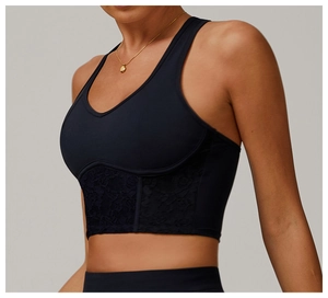 Detailed view of the V-neck sports bra featuring delicate black lace trim and matte fabric