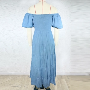 Detail of tiered sky blue off-shoulder maxi dress with puff sleeves and elasticated bodice