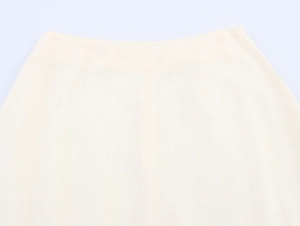 Detail of waist tailoring on cream-colored linen fabric showing breathable texture