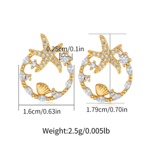 Detail view of gold starfish and shell earrings with zircon stones and size measurements