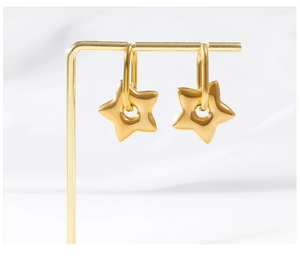 Macro shot of 18K gold plated puffy star hoop earrings hanging on a metal display stand