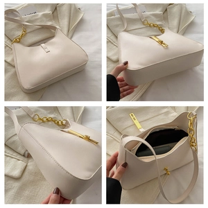 Detail of beige underarm bag showing the golden piston clasp and metallic chain strap