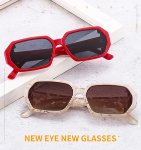 Detailed view of red and marble texture irregular sunglasses with thick frames and UV400 lenses