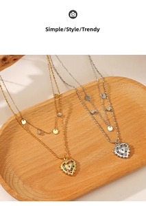 Close-up of double-layer heart necklaces with colorful rhinestones in a wooden tray
