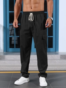 Detail of men's black cargo pants featuring elastic waist and white contrast drawstring