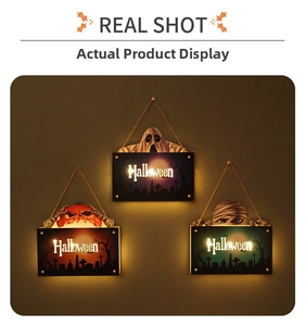 Close-up of three glowing Halloween door signs featuring ghost, pumpkin and mummy designs