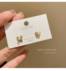 Close-up of heart-shaped pearl earrings with 925 silver needles and micro-inlaid stones