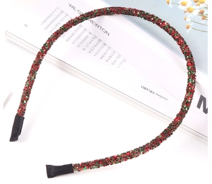 Detailed view of festive red and green glitter headband resting on a fashion magazine