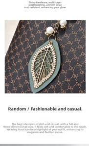 Macro detail of luxury brown tote bag showing gold leaf pendant and monogram pattern