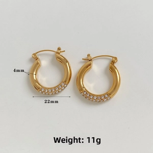 Macro shot of gold-plated C-shaped earrings with triple-row cubic zirconia detail
