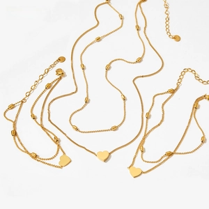 Macro detail of gold-plated stainless steel double heart anklet with bead chain