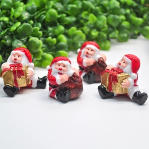 Miniature Santa Claus figurines with gold gift box and red sack for Christmas decor
