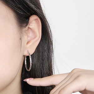 Detailed close-up of 30mm silver twisted hoop earrings crafted from sleek titanium steel