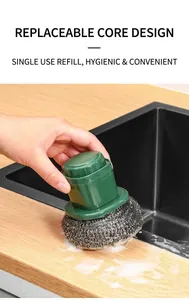 Close-up of kitchen cleaning brush with green handle and replaceable stainless steel scrubber