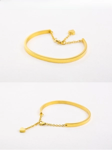Detail of 18K gold plated stainless steel C-shape bracelet with heart pendant charm