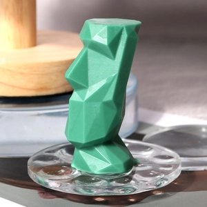 Macro-opname van groene low poly Moai siliconen mal met geometrische facetten en textuur
