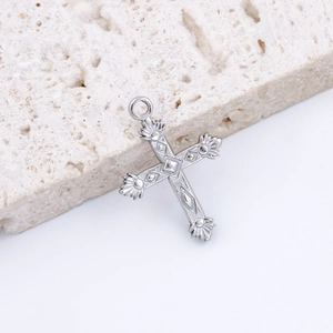 Macro shot of silver stainless steel cross pendant with detailed geometric carvings