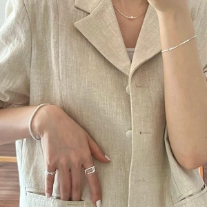 Silver jewelry set featuring a pearl necklace and minimalist rings on a female model