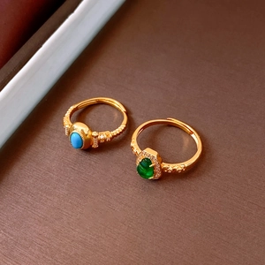 Detailed view of vintage gold rings with blue turquoise and green stones and zircons