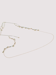 Detailaufnahme der goldenen Brillenkette mit türkisfarbenen Perlen und Herzanhänger