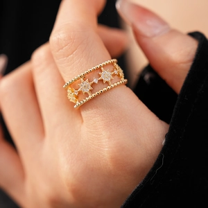 Detail of gold double-layered star ring with zircon inlay on a model's hand