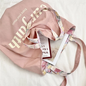 Detail view of the pink floral canvas tote bag featuring faith and music print