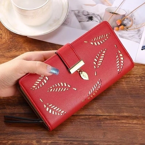 Detail of red long PU leather wallet with hollow leaf design and gold leaf pendant
