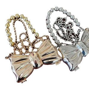 Clutch metalliche a fiocco color oro e argento con eleganti manici in perle su bianco