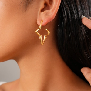 Close-up of 18K gold plated starburst earring with zircon inlay worn by model