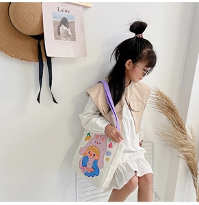 Detail of canvas tote bag featuring cute cartoon girl illustration and purple handles
