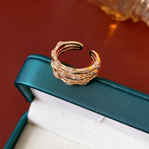 Detailed close-up of golden bamboo joint ring with sparkling zircons on a jewelry box