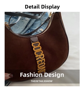Detailed close-up of brown suede moon bag featuring golden COCREONE logo lettering