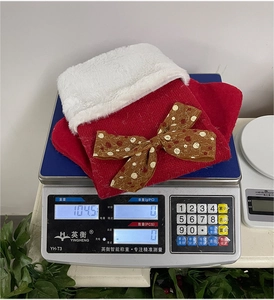 Vue détaillée de la chaussette de Noël en tricot pesant 104,5g sur une balance