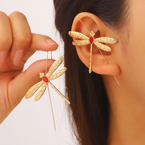 Détail du bijou d'oreille libellule avec pierre rouge et ailes dorées texturées