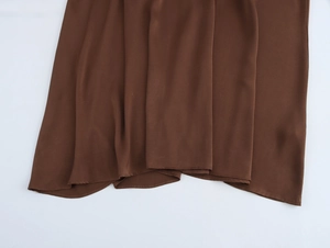 Detail showing the silky texture and elegant folds of the brown chiffon dress fabric