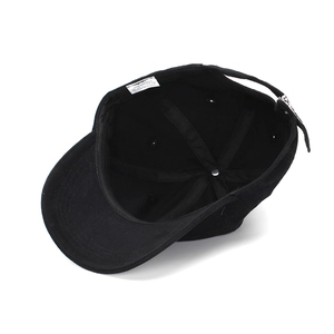 Internal view of a black cotton baseball cap showing 100% cotton label and metal buckle